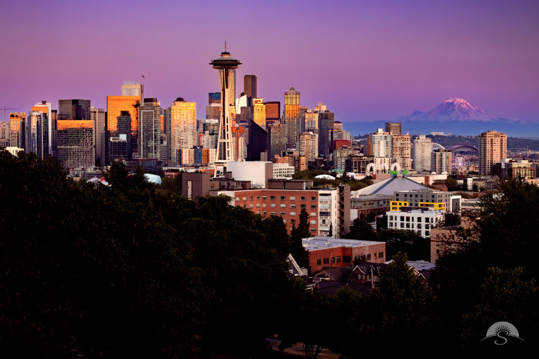 A photo of the Seattle skyline and Mount Rainier at dusk.