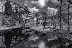 Experience the timeless beauty of Yosemite National Park with this striking black and white landscape photo of Upper Yosemite Falls, as seen from the iconic Swinging Bridge. The monochrome palette enhances the dramatic contrast between the rushing waterfall, rugged granite cliffs, and the serene Merced River below. Capturing the raw power and elegance of one of Yosemite’s most breathtaking sights, this fine art print brings depth, texture, and a sense of adventure to any space. Perfect for nature lovers, photography enthusiasts, and those who appreciate classic, high-contrast imagery, this piece is a must-have addition to your collection. Order yours today and bring the majesty of Yosemite into your home!